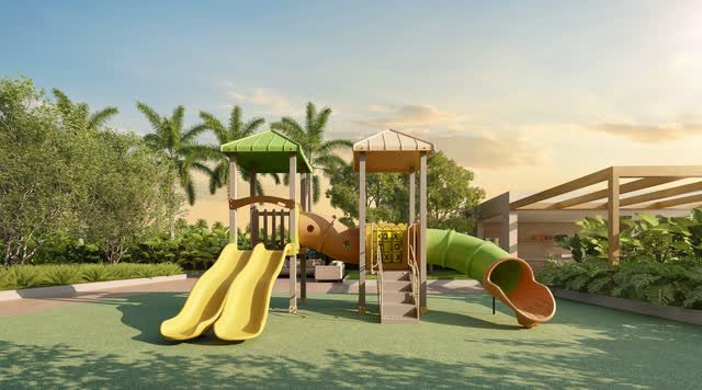 Playground com escorregadores amarelos e verdes e torres de brinquedos, com árvores ao fundo