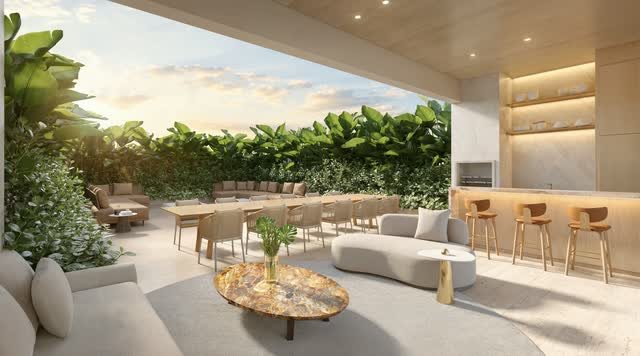 Área gourmet com terraço aberto, mesa longa, bancada de bar com banquetas e sofás entre a vegetação
