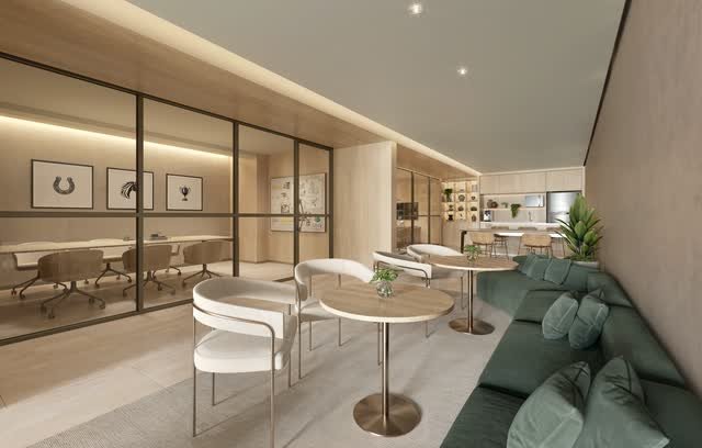 Sala de reuniões envidraçada e lounge com sofá verde e mesas de apoio
